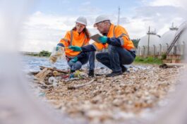 Two environmental management experts wearing protective gear such as hard hats