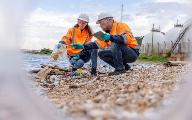 Two environmental management experts wearing protective gear such as hard hats